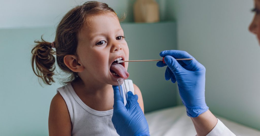 Photo of a young girl saying "ahhh" at the ENT office